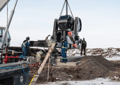 A team of men focused on working together on a large machine